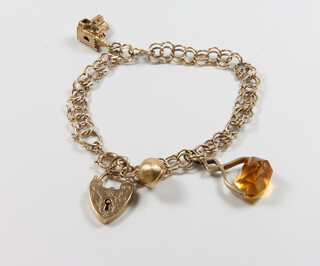 A 9ct yellow gold bracelet with heart shaped padlock and 2 charms together with a hardstone seal, gross weight 13 grams