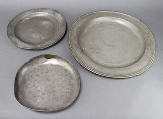 A 17th/18th Century circular pewter charger, the top marked DL, 46cm diam. (some corrosion to the centre), 1 other unmarked 34cm diam. (misshapen) and a circular dish with touch mark 3cm h x 28cm dia. (misshapen) 