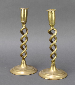 A pair of brass spiral turned candlesticks on circular bases 26cm h 