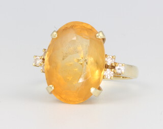 A 14ct yellow gold oval citrine and diamond ring, the centre stone 15mm x 10mm, 6.3 grams, size P 1/2