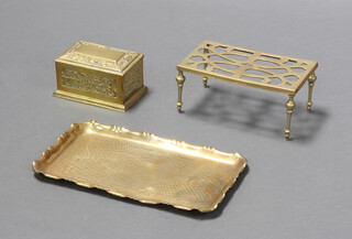 A 19th Century rectangular embossed brass casket with hinged lid 8cm x 17cm x 11cm, a rectangular planished brass dressing table tray 36cm x 20cm and a brass footman the base marked RD530 568 11cm h x 25cm w x 13.5cm d