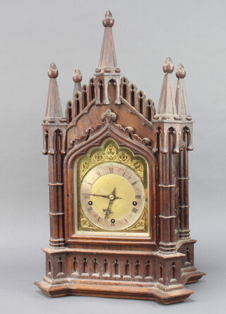 A 19th Century German striking bracket clock with 18cm gilt dial, silvered chapter ring and Roman numerals, striking on 5 gongs, complete with pendulum and key, contained in a carved oak Gothic style case, with bracket, the back plate marked W & HSCH 66cm h x 27cm w x 38cm d 