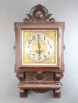 A 19th Century Continental 8 day striking wall clock, the 30cm dial with silvered chapter ring, contained in a heavily carved oak case, complete with pendulum but without key 106cm h x 47cm w x 14cm d 