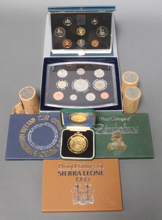 A 2000 commemorative coin set, 4 other cased coin sets, a gilt crown and rolls of commemorative crowns 