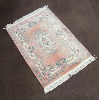 A peach ground and floral patterned Chinese rug with central medallion 192cm x 122cm 