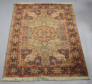 A green and blue patterned Persian style rug with central medallion with a 4 row border 226cm x 154cm 