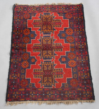 A red and blue ground Belouche rug with 3 stylised diamonds to the centre 136cm x 85cm 