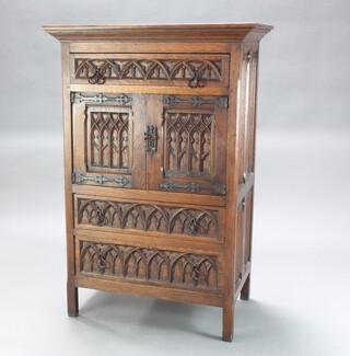 A 17th Century style carved oak Ipswich style cabinet, the upper section fitted a drawer above cupboard enclosed by panelled doors above 2 long drawers 123cm h x 82cm w x 51cm d  
