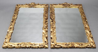 A pair of Georgian style rectangular plate wall mirrors contained in carved and pierced gilt frames 130cm x 69cm 
