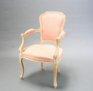 A limed oak Empire style open armchair upholstered in pink and white material, raised on cabriole supports 98cm h x 57cm w x 52cm w (seat 40cm x 42cm) 