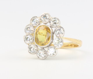 An 18ct yellow gold and platinum yellow sapphire and diamond cluster ring, the central stone approx, 1.35ct, the diamond surround approx. 0.95ct, size N