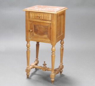 A 19th Century French bleached walnut bedside cabinet with pink veined marble top, fitted a drawer above cupboard enclosed by a panelled door, raised on turned and fluted supports with H framed stretcher 84cm h x 41cm w x 35cm d 
