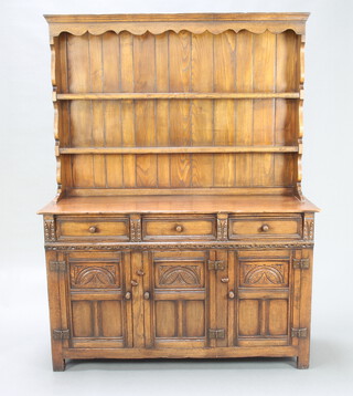 A 17th Century style carved oak dresser, the raised back fitted 2 shelves, base fitted 3 drawers above triple cupboards enclosed by panelled doors 180cm h x 187cm w x 46cm d 