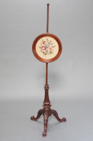 A William IV carved mahogany pole screen base raised on pillar and tripod supports with associated stem and circular Berlin wool work panel 128cm h x 43cm w x 43cm d 