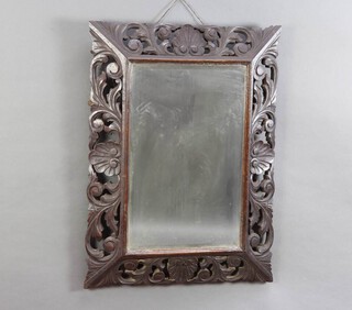 A Victorian rectangular plate mirror contained in a carved and pierced oak frame 59cm h x 80cm w 