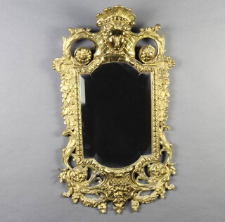 A Victorian oval shaped bevelled plate mirror contained in a pierced gilt metal Rococo style frame surmounted by a mask 64cm h x 38cm w 