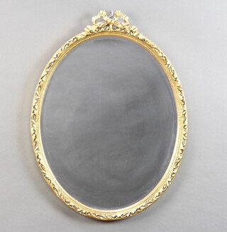A Georgian style oval bevelled plate mirror contained in a gilt frame surmounted by a swag 58cm x 44cm 
