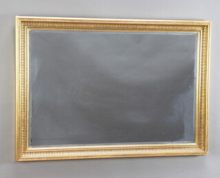 A rectangular bevelled plate wall mirror contained in a decorative gilt frame 72cm h x 101cm h 