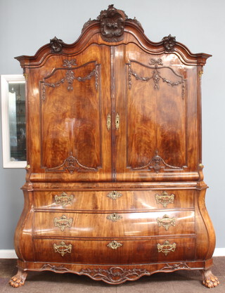 A 19th Century Dutch walnut linen press, the arched upper section heavily carved throughout, the interior fitted shelves and 2 long drawers above a recess, above 3 long drawers enclosed by a pair of panelled doors, the base of bombe form fitted 3 long drawers raised on hoof supports 244cm h x 188cm w x 74cm d 