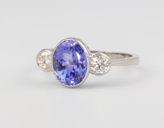 A platinum three stone tanzanite and diamond ring, the central tanzanite approx 2.20ct supported by diamonds approx. 0.42ct, size M