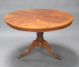 A Regency circular quarter veneered walnut breakfast table, raised on a turned column and tripod base, brass paw feet 75cm h x 120cm 