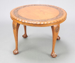 A 1920's circular carved Burmese hardwood occasional table raised on cabriole supports 42cm x 61cm 