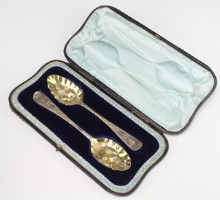 A pair of George III engraved and gilt cased berry spoons, rubbed marks, 114 grams 