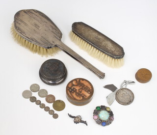 A silver backed hair brush and clothes brush Birmingham 1936, a repousse pill box, an 1834 5 franc coin pocket knife with scissors, nail file and knife, a small collection of coins and minor items