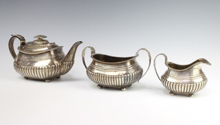 A Georgian silver demi-fluted 3 piece tea set raised on ball feet with monogram, gross weight 1268 grams, rubbed marks 