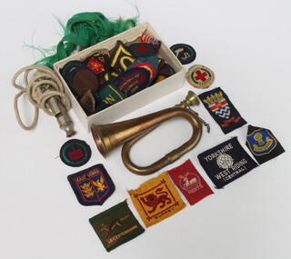 A miniature copper and brass bugle 13cm, a whistle and minor cloth badges 