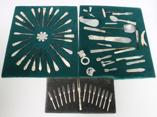 14 mother of pearl 2 handled forks, a mounted display of mother of pearl handled dressing table accessories, a ditto with corkscrew paperknife etc 