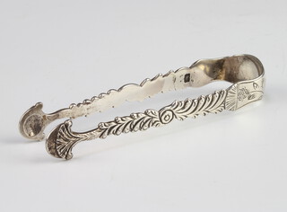 A pair of Georgian silver tongs with shell bowls 12cm, marks are rubbed, 38 grams  