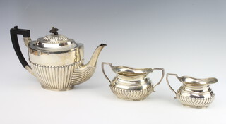 A Victorian silver 3 piece demi-fluted tea set with ebony mounts, the teapot Sheffield 1896, sugar bowl and cream jug London 1897, gross weight 926 grams 