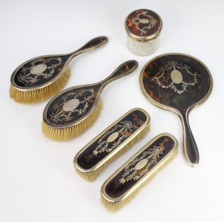 A George V silver and tortoiseshell piquet dressing table set comprising 2 hair brushes, 2 clothes brushes, hand mirror and a mounted bottle Birmingham 1916 and 1917  