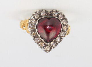 A Victorian style yellow gold and silver garnet and heart shaped surround ring, the garnet approx. 5ct, the diamonds 0.60ct, size M