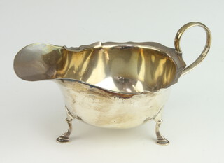 A silver sauce boat/cream jug with wavy border, raised on 3 hoof supports Birmingham 1926, 88 grams 