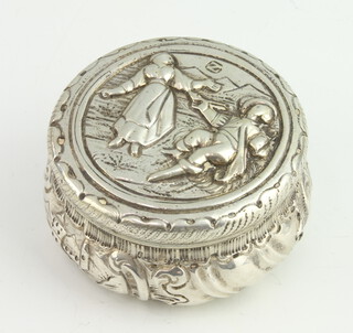 A circular Continental repousse silver box and cover decorated romantic scenes, 62 grams