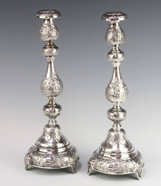 A pair of Continental embossed silver candlesticks with detachable sconces, London 1913, 34cm h x 12cm, the bases are weighted 