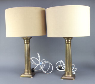 A pair of gilt metal reeded column table lamps with Doric capitals on square bases, complete with shades 40cm x 13cm x 13cm 