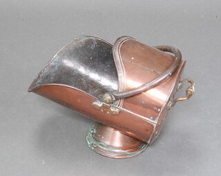A Victorian copper helmet shaped coal scuttle with swing handle raised on a circular base 37cm h x 42cm w x 30cm d 
