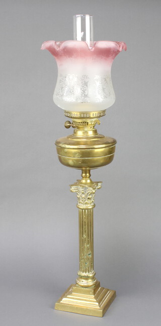 A 19th Century style gilt metal oil lamp reservoir raised on a reeded column with Corinthian capital and stepped base, the burners marked Made in England Duplex with associated glass shade and chimney  76cm h x 16cm 