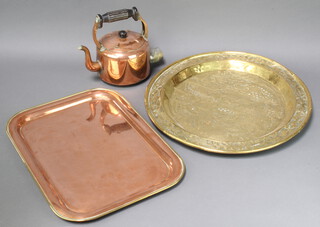 An early copper kettle, an Eastern embossed brass tray 35cm diam. and a rectangular copper and brass tea tray 33cm x 46cm 