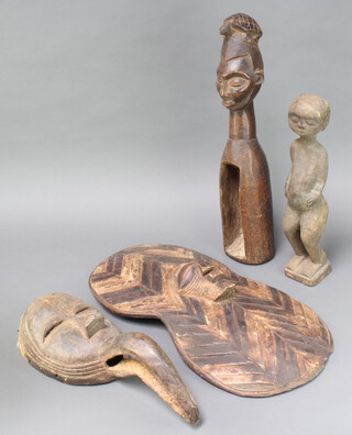 An African carved hardwood shield 56cm h x 28cm, ditto figure of a gentleman 40cm x 7cm x 8cm, ditto mask 43cm x 7cm and a ditto figure with bottle shaped body 53cm x 12cm x 10cm 