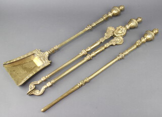 A 3 piece 19th Century style polished brass fireside companion set comprising poker, shovel and tongs with mask decoration 
