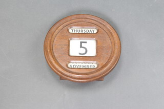A perpetual calendar contained in a circular oak case the reverse marked British Railways 6cm x 31cm 