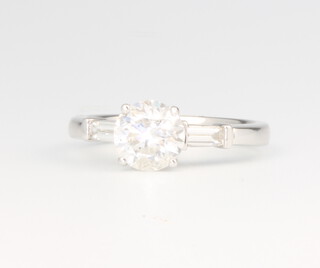 An 18ct white gold brilliant cut diamond ring with baguette shoulders, the centre stone 1.57ct, the baguettes 0.22ct, size M, 4.5 grams