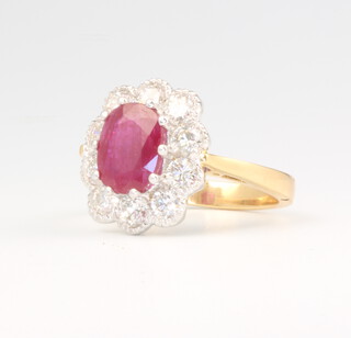 An 18ct yellow gold oval ruby and diamond cluster ring, the centre stone approx. 2.50ct surrounded by 10 brilliant cut diamonds approx. 1.5ct, size M 1/2, 6.4 grams