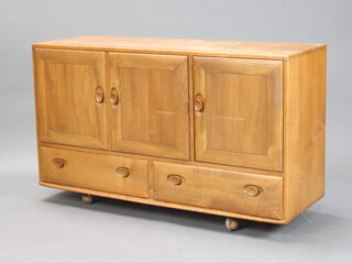 An Ercol light elm Windsor sideboard fitted 3 cupboards above 2 drawers 76cm h x 129cm w x 43cm d (some water stains and ring marks to the top, scratch to the centre of the left hand door, light scratches in places and sun bleaching to the front) 