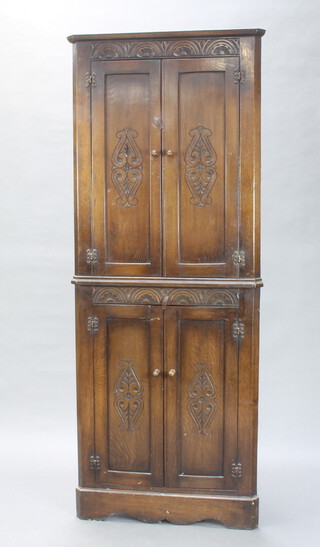 A carved oak double corner cabinet with arcaded decoration enclosed by panelled doors 181cm h x 71cm w x 51cm d 