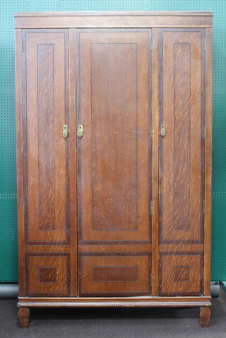 BCM/HL, an Art Deco triple oak wardrobe with moulded cornice enclosed by panelled doors, 192cm h x 119cm w x 46cm d (some scuff marks in places) 